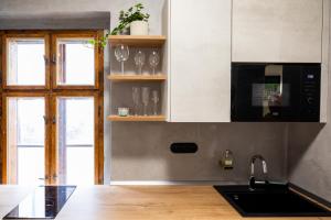 a kitchen with a sink and some glasses on shelves at Residence 1892 - Apartment 3 in Bratislava