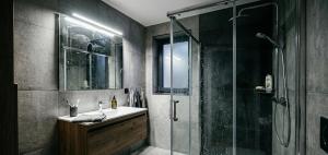 a bathroom with a glass shower and a sink at Kule Rezidance Hotel in Seyhan