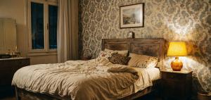 a bedroom with a bed with a lamp and wallpaper at Kule Rezidance Hotel in Seyhan