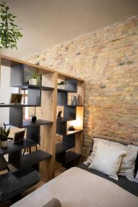 a bedroom with a brick wall with a bed and shelves at Residence 1892 - Apartment 3 in Bratislava