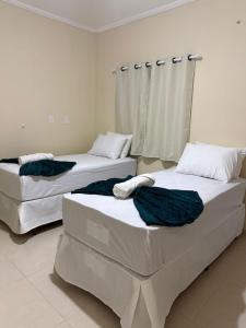 two beds sitting in a room at Hotel e Pousada Santa Helena in Potim