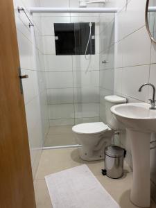 a bathroom with a toilet and a glass shower at Hotel e Pousada Santa Helena in Potim