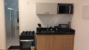 a small kitchen with a sink and a stove at Casa da Dinda 107 in Rio das Ostras +2 photos