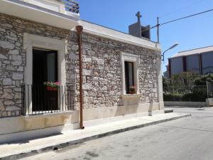 a stone building with two windows and a balcony at La casa di Bice alloggio 1 in Cassibile