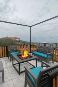 a patio with chairs and a fire pit on a deck at شاليه غصن in Ajloun