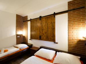 a bedroom with two beds and a brick wall at Apartmány 13 Přízemí 2 in Seč