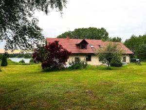a house with a red roof on a green field at Dom Acapulco in Kromszewice