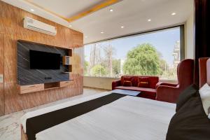 a bedroom with a bed and a flat screen tv at Hotel O J K Galaxy Hotel in Juhi Bari +24 photos