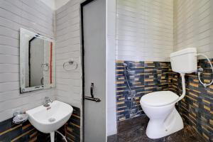 a bathroom with a toilet and a sink at Hotel O J K Galaxy Hotel in Juhi Bari