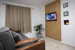 a living room with a couch and a flat screen tv at Berenice Concept Residence - By Temporada Expert in Feira de Santana