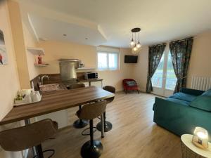 a kitchen and living room with a blue couch at La Villa Port Winston - Face Mer Chambres & Studios in Saint-Côme-de-Fresné