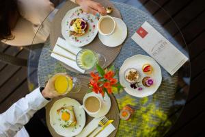 a table topped with plates of food and drinks at Blumen Hotel Boutique in Canela