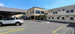 a white truck parked in a parking lot in front of a building at Hotel do Porto in Porto Velho