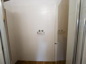 a shower stall in a bathroom with white tiles at Apartmány 13 Přízemí 2 in Seč +20 photos
