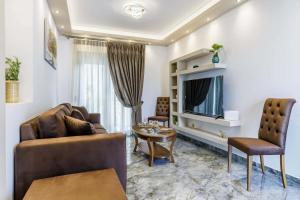 a living room with a couch and a tv at The Hidden Gem Skopelos - Elegant Island Retreat in Skopelos Town