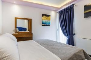 a bedroom with a bed and a mirror and a window at The Hidden Gem Skopelos - Elegant Island Retreat in Skopelos Town