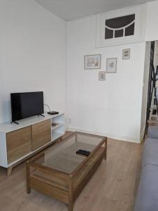 a living room with a tv and a coffee table at Appartement en centre ville in Ambert