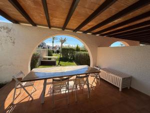 a table and chairs on a patio with an archway at Les Oliveres Beach in Perelló