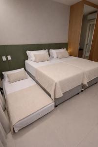 two beds sitting next to each other in a room at Stúdio FRENTE MAR Centro de Convenções Salvador ArtStudio in Salvador