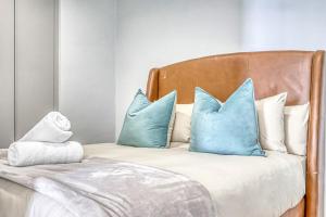 a bed with blue pillows on top of it at Caica Executives at Ellipse 4103 in Midrand +20 photos