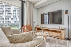 a living room with two chairs and a tv at Caica Executives at Ellipse 4103 in Midrand