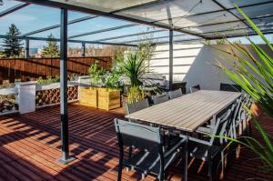 a patio with a wooden table and chairs on a deck at Appartement RoofTop - Montélimar in Montélimar
