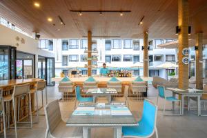 a restaurant with tables and chairs and a man in a building at LIV Hotel Phuket Patong Beachfront in Patong Beach