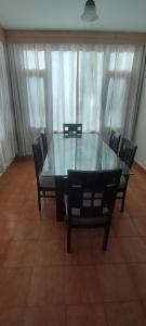 a glass table and chairs in a room at Peaceful huts in Manāli