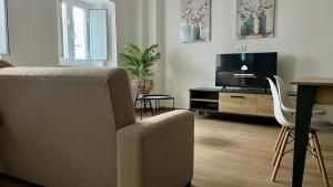 a living room with a couch and a tv and a table at Ducal Guest House in Vila Viçosa +5 photos