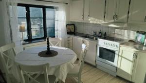 a kitchen with a table and chairs and a kitchen with white cabinets at Lilla lugnet in Ystad