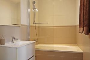 a bathroom with a shower and a sink and a tub at Au logis de Pézenas in Pézenas