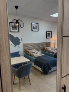 ein Zimmer mit zwei Betten, einem Tisch und einem Schreibtisch in der Unterkunft Studio Olecko in Olecko