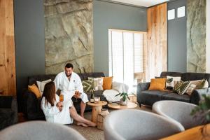 a man and woman sitting in a living room at Leśniczanka in Brenna