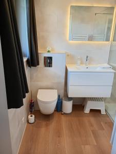 a bathroom with a white sink and a toilet at Family Bungalow De Strandjutter 8 people in Middelkerke