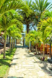 a path with palm trees and tables and a building at Bungalows Spilberg in Colán