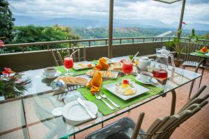 un tavolo in vetro con cibo e bevande su un balcone di Range Kandy a Kandy