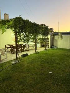 a park with picnic tables and trees in the grass at La Casa de Alicia in Chivilcoy