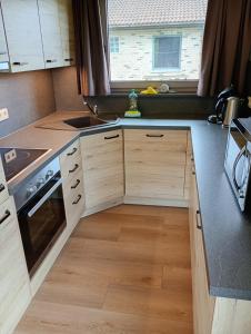 a kitchen with wooden cabinets and a window at Family Bungalow De Strandjutter 8 people in Middelkerke +20 photos