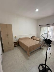 a bedroom with two beds and a fan in it at La Casa de Alicia in Chivilcoy