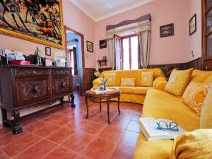 a living room with a yellow couch and a table at Medieval country house Señorío de Montero in Cenizate