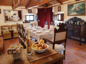 a dining room with a table with a bowl of fruit at Medieval country house Señorío de Montero in Cenizate
