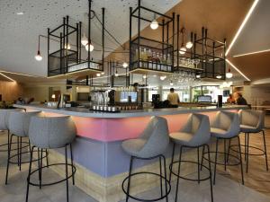 a bar in a restaurant with stools at Novotel Wavre Brussels East in Wavre