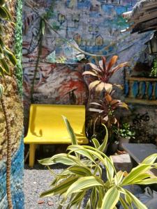 a yellow bench sitting in front of a wall at Espaço Nabucodonosor in Recife