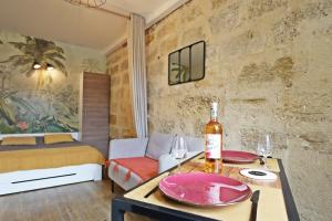 a room with a bottle of wine on a table at Au logis de Pézenas in Pézenas +27 photos
