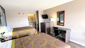 a hotel room with a bed and a desk at Super 8 by Wyndham Marianna I-10 in Marianna +15 photos