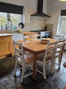 a kitchen with a wooden table and some chairs at The Bungalow Killybegs in Killybegs