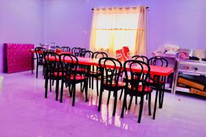 a dining room with a red table and chairs at Sky View Guest House in Shānti Niketan