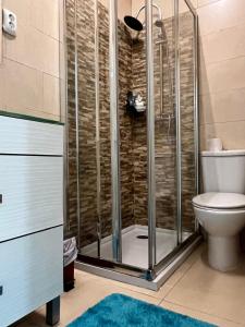 a shower stall in a bathroom with a toilet at Quarto confortável in Amadora