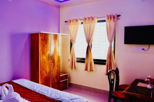 a bedroom with a bed and a window with curtains at Sky View Guest House in Shānti Niketan