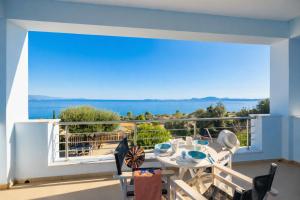 a balcony with a table and chairs and a view of the ocean at Villa Alya View in Barbati